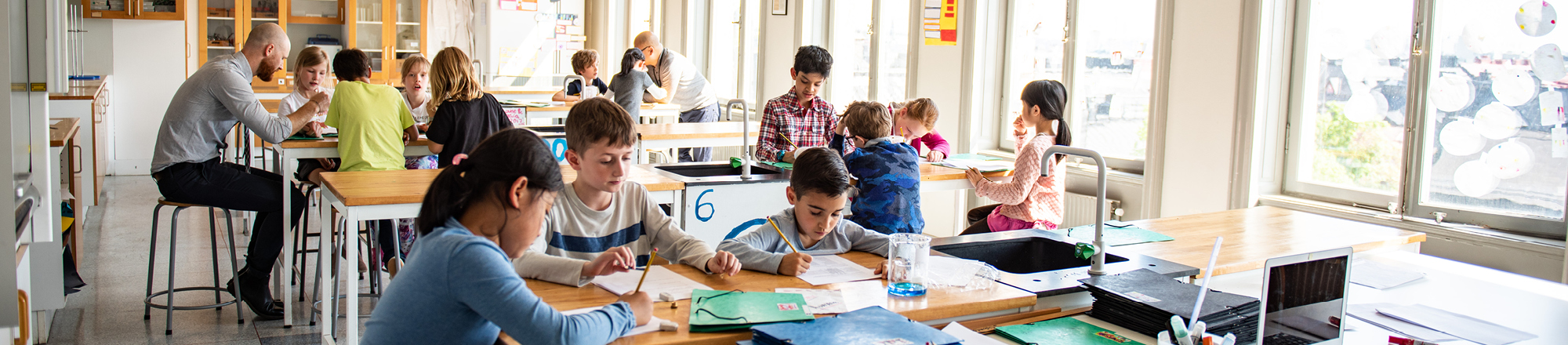 A busy classroom with children working at desks