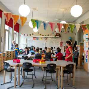 A classroom with children working beneath colourful bunting