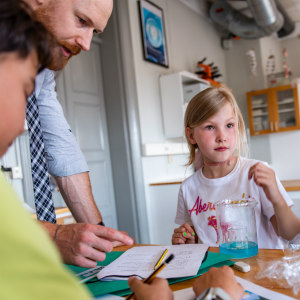 Girl in science lesson with beaker of liquid