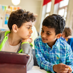 Two boys working together at a laptop